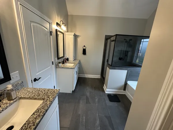 a bathroom with a granite countertop sink toilet and shower