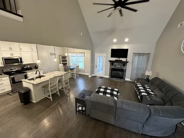 a living room with furniture and a flat screen tv with wooden floor