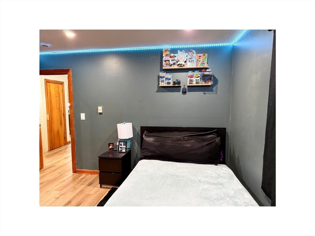 9 Alpha Street Haverhill, MA 01832 - Photo 11 of 14 a bedroom with a bed and a wall painting