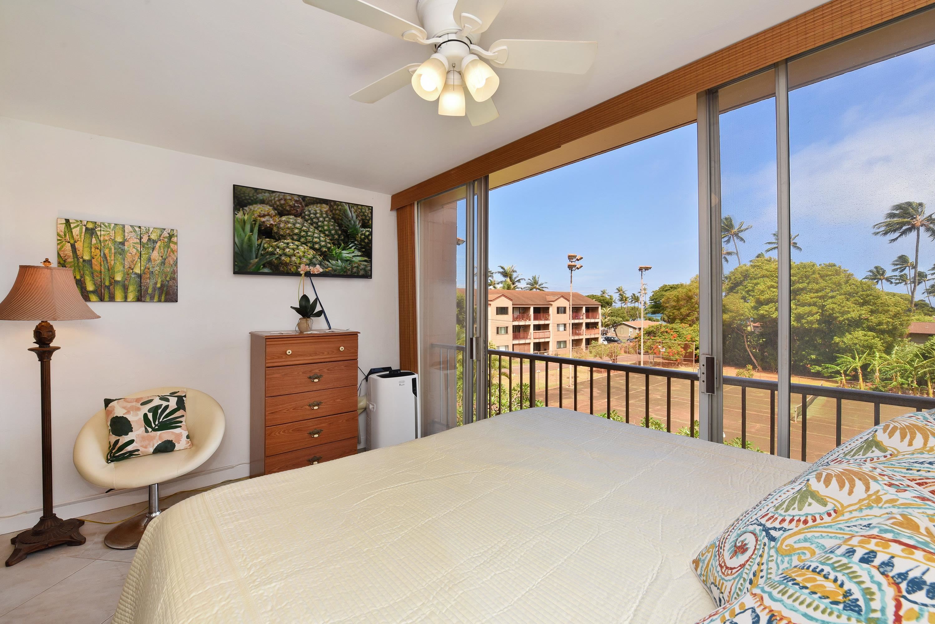 a bedroom with a bed and a flat tv screen on dresser