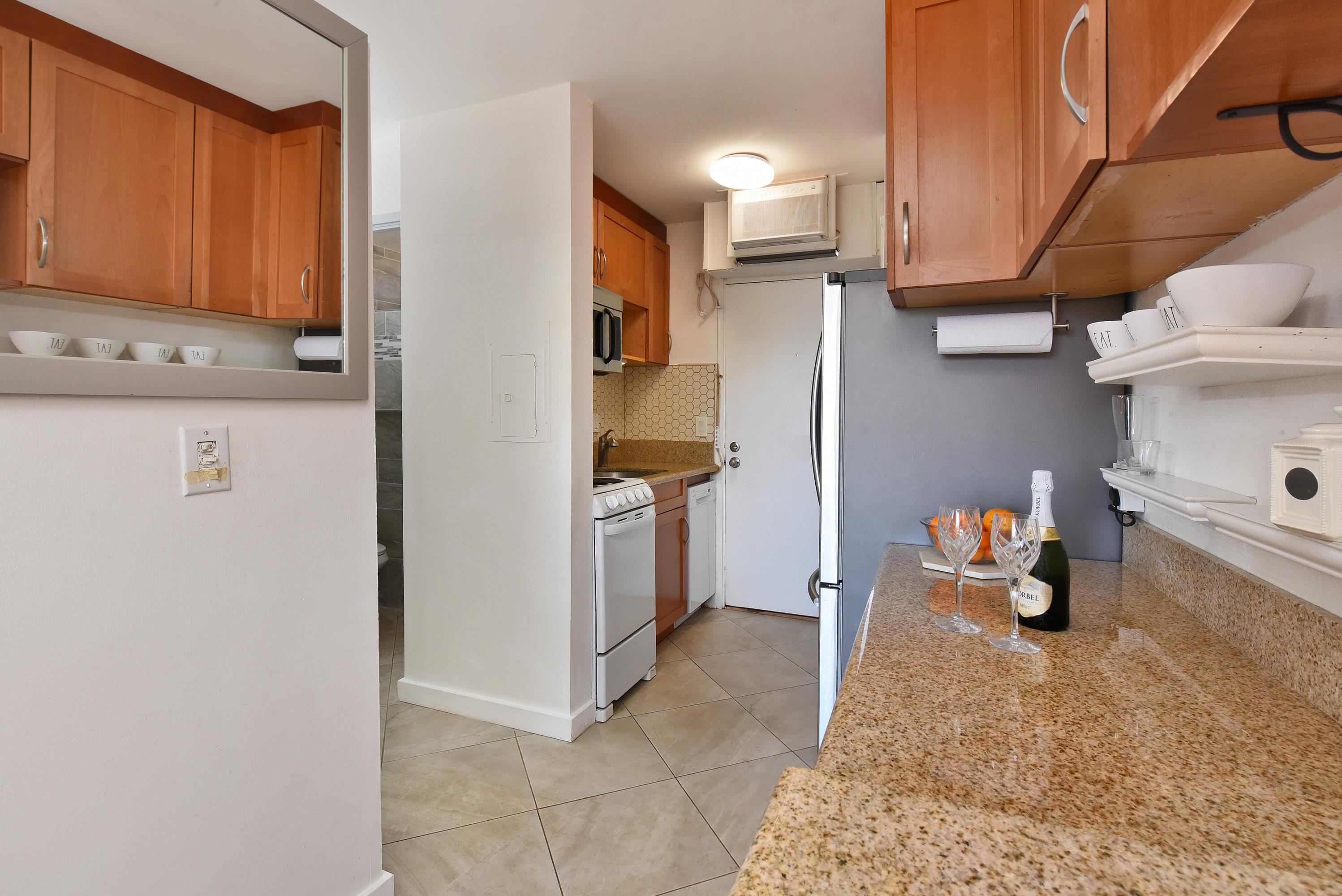 3660 Lower Honoapiilani Road, Unit 302 Lahaina, HI 96761 - Photo 15 of 27 a kitchen with a refrigerator and cabinets