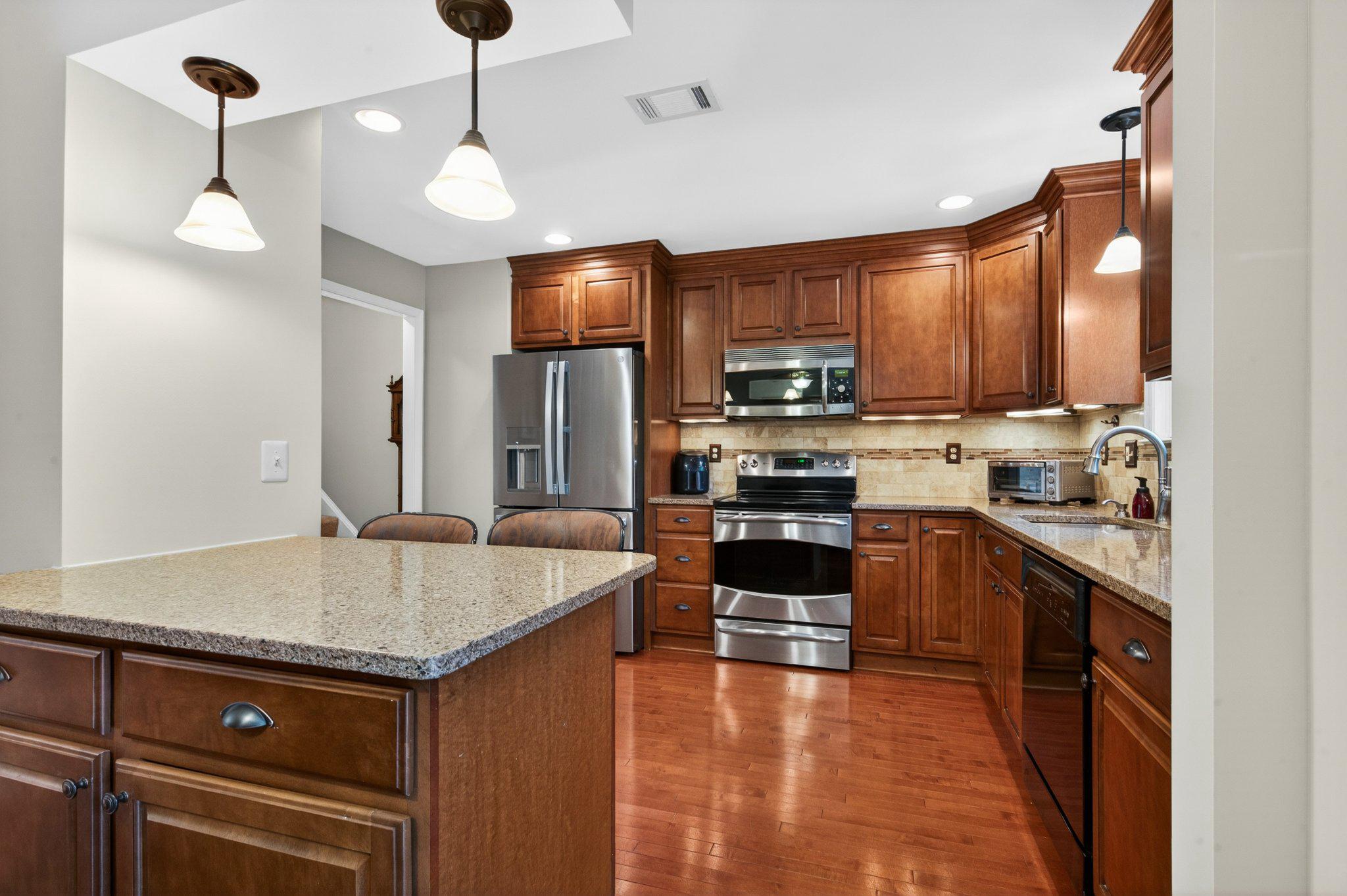 11737 Dry River Court Reston, VA 20191 - Photo 3 of 45 a kitchen with stainless steel appliances granite countertop a sink refrigerator and cabinets