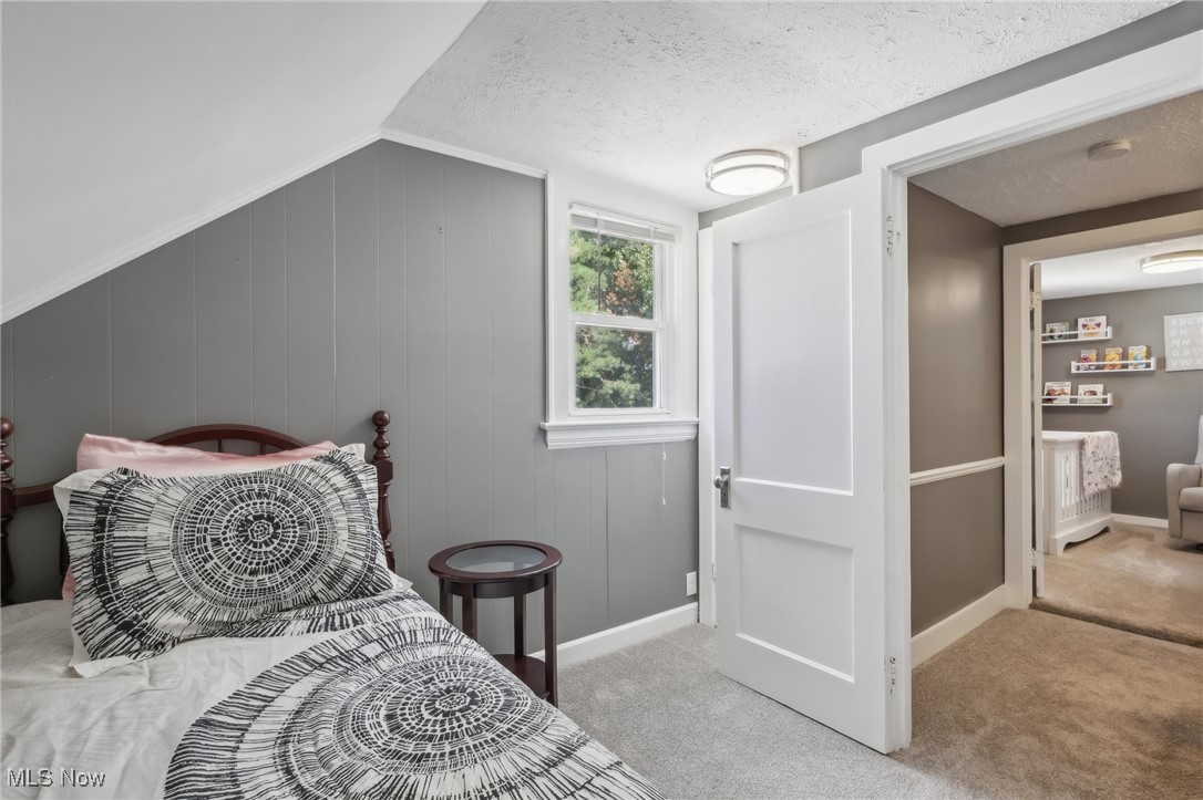1567 Roselawn Road Cleveland, OH 44124 - Photo 24 of 29 Bedroom featuring light carpet, a textured ceiling, and lofted ceiling