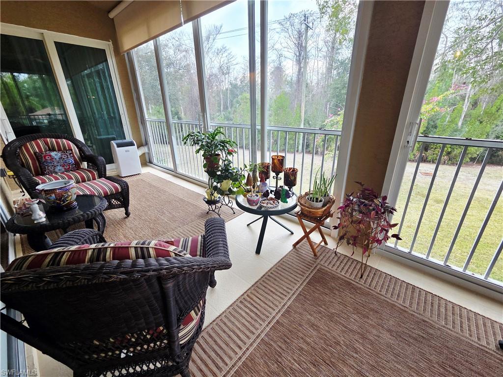 6775 Huntington Lakes Circle, Unit 202 Naples, FL 34119 - Photo 15 of 46 a living room with furniture and a floor to ceiling window