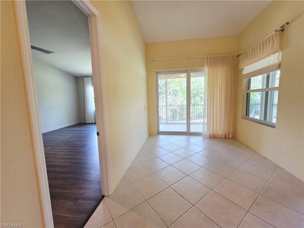 6775 Huntington Lakes Circle, Unit 202 Naples, FL 34119 - Photo 18 of 46 a view of an empty room with wooden floor and a window