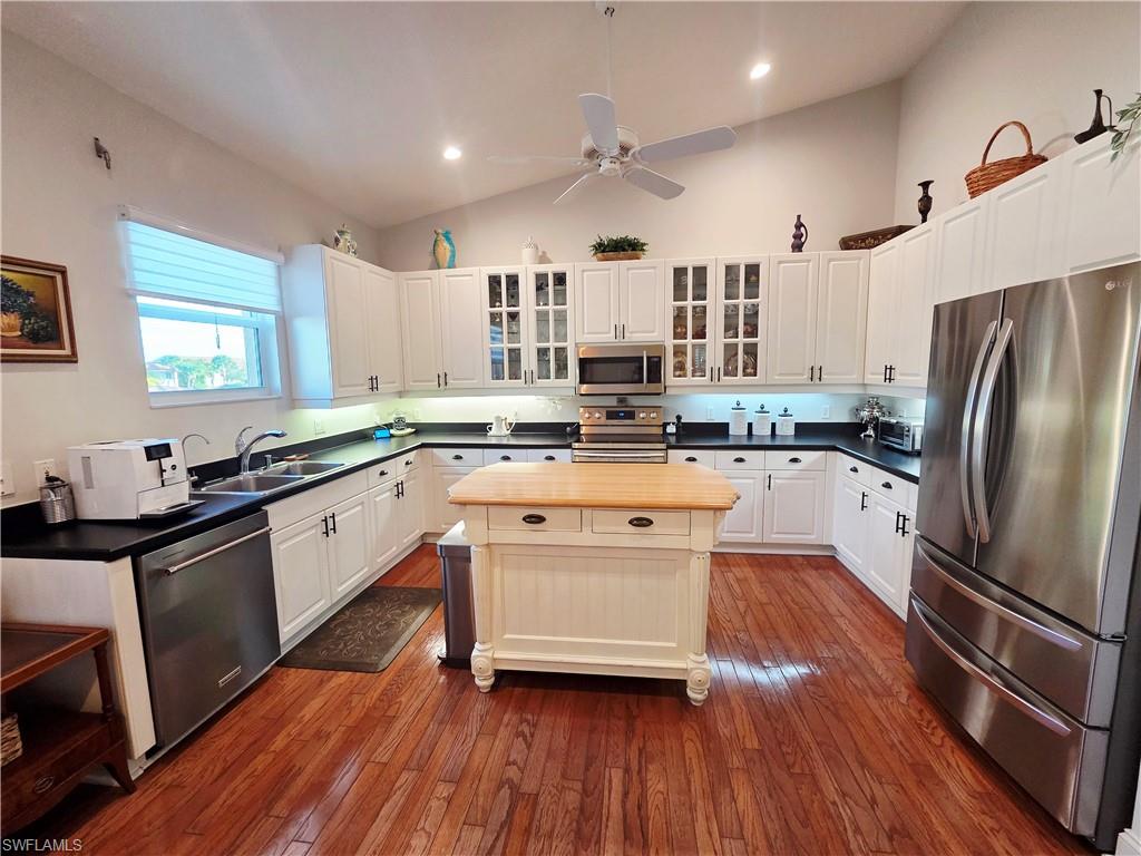 6775 Huntington Lakes Circle, Unit 202 Naples, FL 34119 - Photo 2 of 46 a kitchen with stainless steel appliances a sink cabinets and wooden floor