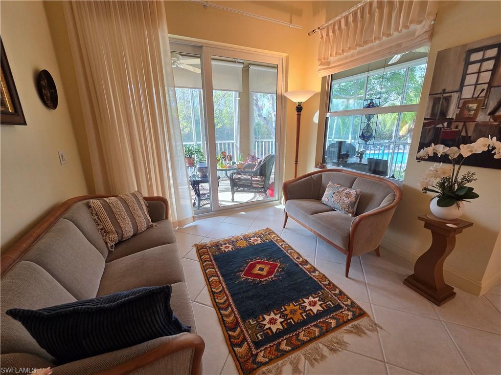 6775 Huntington Lakes Circle, Unit 202 Naples, FL 34119 - Photo 22 of 46 a living room with furniture and a large window