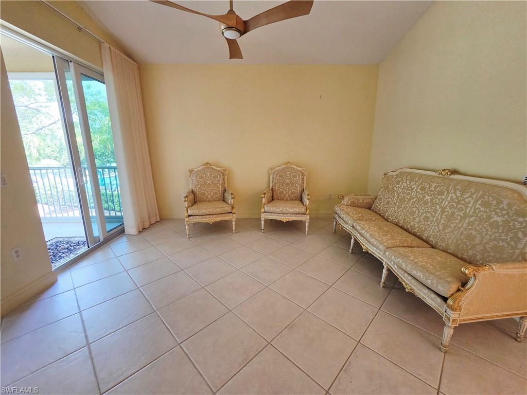 6775 Huntington Lakes Circle, Unit 202 Naples, FL 34119 - Photo 23 of 46 a living room with furniture and a floor to ceiling window