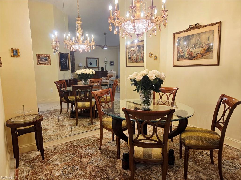 6775 Huntington Lakes Circle, Unit 202 Naples, FL 34119 - Photo 26 of 46 a view of a dining room with furniture and chandelier