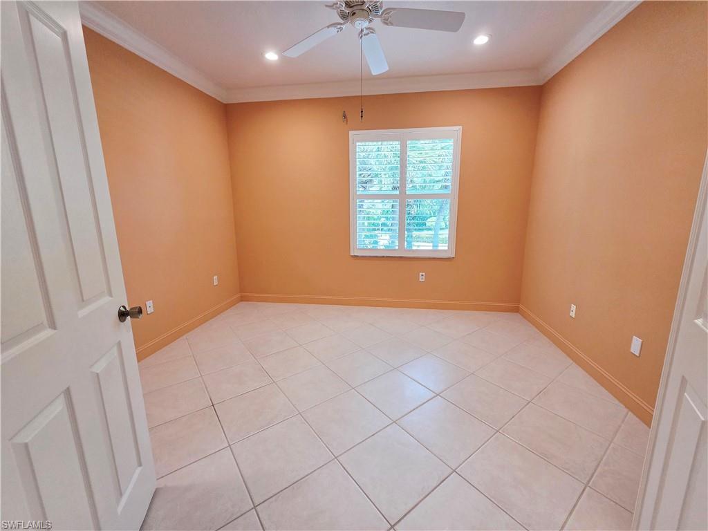 6775 Huntington Lakes Circle, Unit 202 Naples, FL 34119 - Photo 30 of 46 an empty room with a window and a chandelier fan