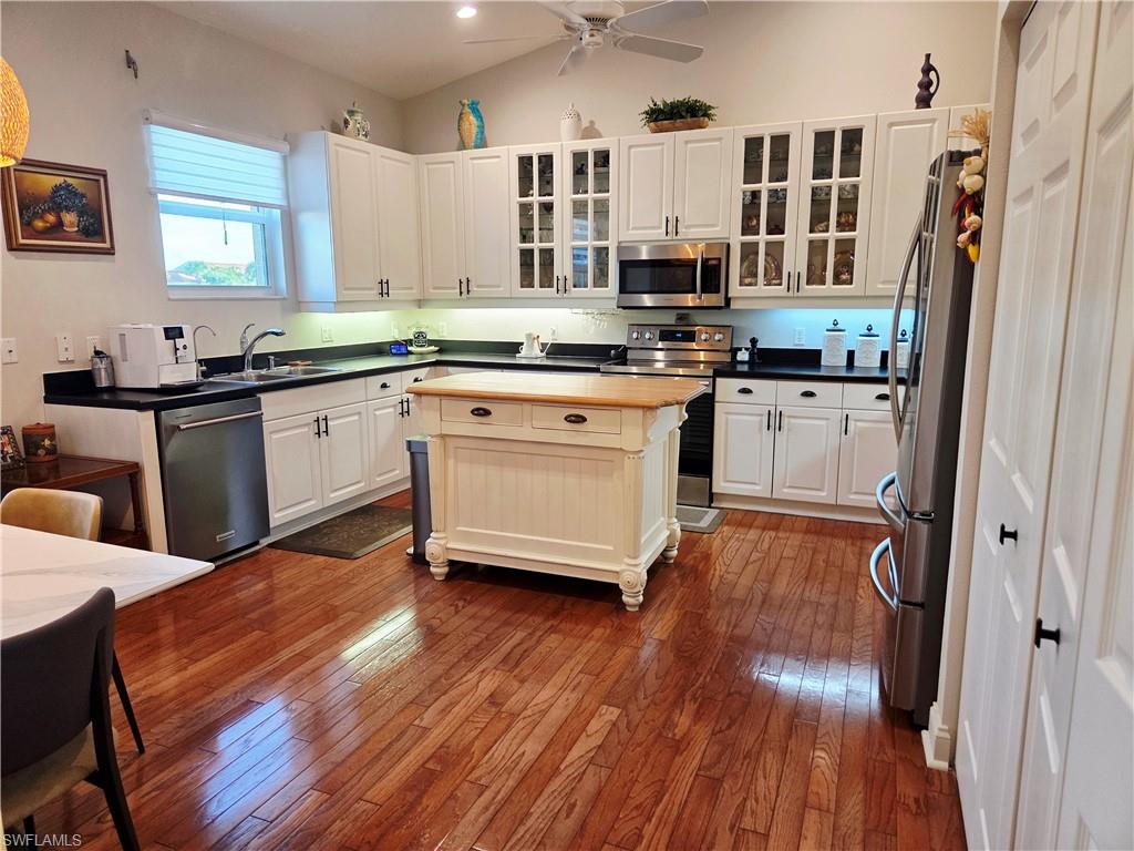 6775 Huntington Lakes Circle, Unit 202 Naples, FL 34119 - Photo 3 of 46 a open kitchen with stainless steel appliances granite countertop a stove a sink dishwasher and a refrigerator with wooden floor