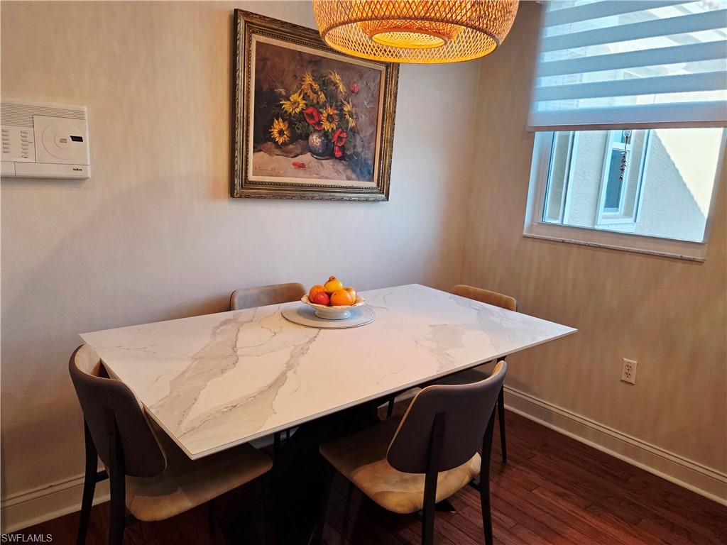 6775 Huntington Lakes Circle, Unit 202 Naples, FL 34119 - Photo 5 of 46 a view of a dining room with furniture and wooden floor