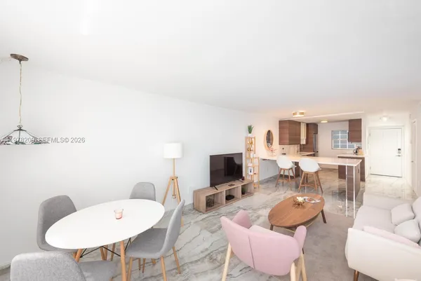 a living room with furniture a flat screen tv and a table