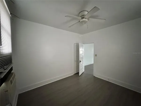 an empty room with a window and a fan