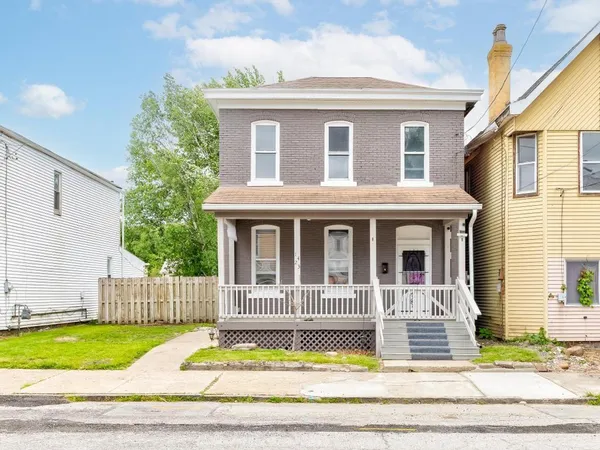 a view of a house with wooden fence and a small yard