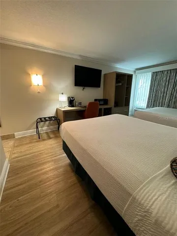 a large bedroom with bed tv and window