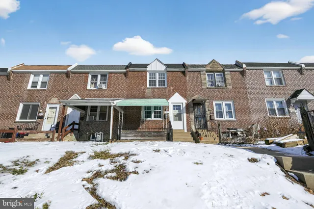a front view of a house with a yard covered in snow