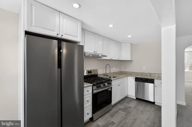 a kitchen with stainless steel appliances a refrigerator a sink and cabinets