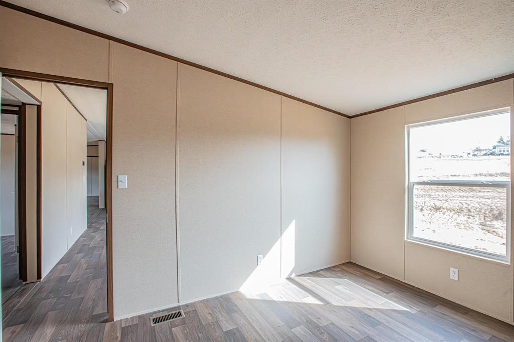109 Draven Drive Springtown, TX 76082 - Photo 18 of 35 a view of an empty room with window and wooden floor
