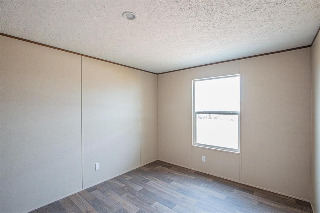 109 Draven Drive Springtown, TX 76082 - Photo 27 of 35 an empty room with wooden floor and windows