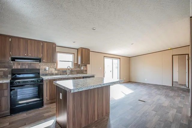 a kitchen with granite countertop a stove and cabinets