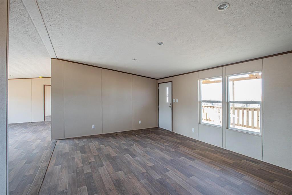 109 Draven Drive Springtown, TX 76082 - Photo 9 of 35 a view of an empty room with wooden floor and a window