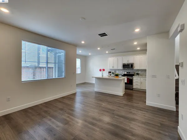 a view of kitchen with kitchen island stainless steel appliances counter top space and cabinets