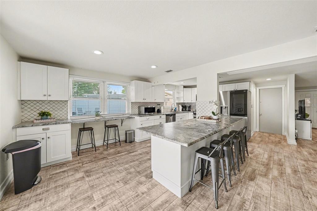 8828 Carmen Lane Port Richey, FL 34668 - Photo 12 of 28 a large kitchen with kitchen island a sink table and chairs