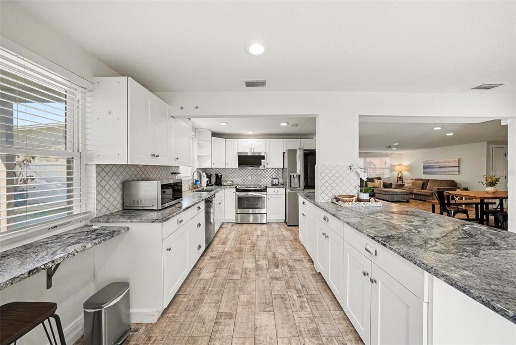 8828 Carmen Lane Port Richey, FL 34668 - Photo 13 of 28 a large kitchen with granite countertop a large counter top appliances and cabinets