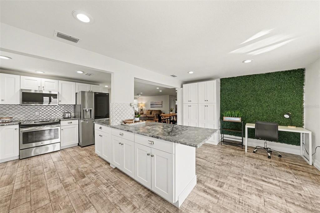8828 Carmen Lane Port Richey, FL 34668 - Photo 14 of 28 a large kitchen with kitchen island a sink stainless steel appliances and cabinets