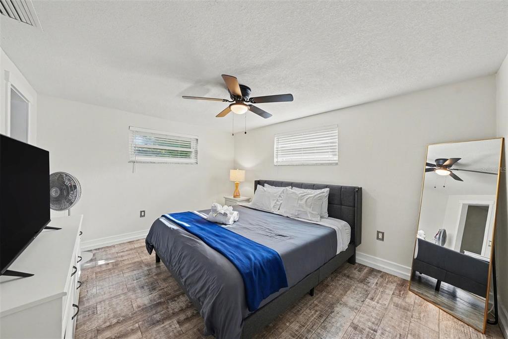 8828 Carmen Lane Port Richey, FL 34668 - Photo 19 of 28 a bedroom with a bed and a flat screen tv