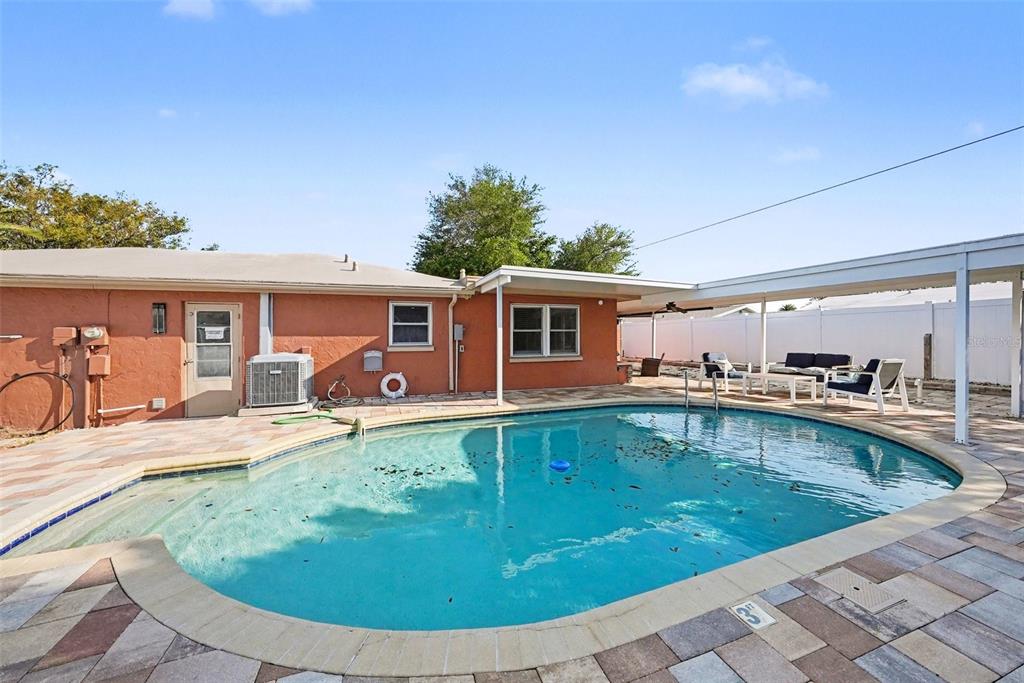 8828 Carmen Lane Port Richey, FL 34668 - Photo 25 of 28 a view of a house with swimming pool and a porch