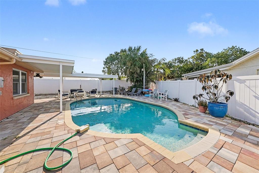 8828 Carmen Lane Port Richey, FL 34668 - Photo 28 of 28 a view of a swimming pool with a lounge chairs