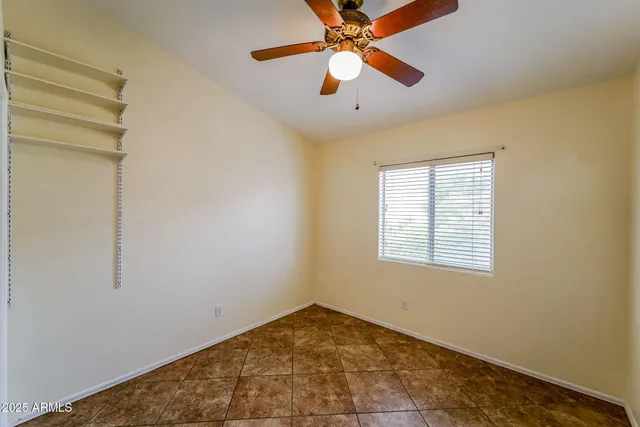 an empty room with windows and fan