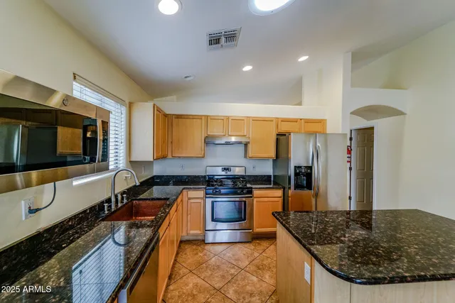 a kitchen with stainless steel appliances granite countertop a stove and a sink
