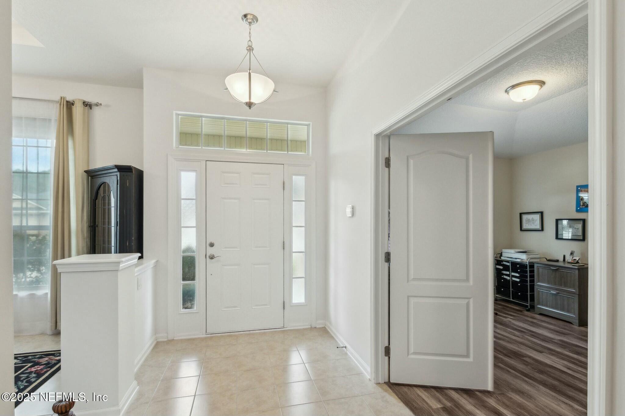 86197 Fortune Drive Yulee, FL 32097 - Photo 3 of 36 a view of a hallway with wooden floor and cabinet