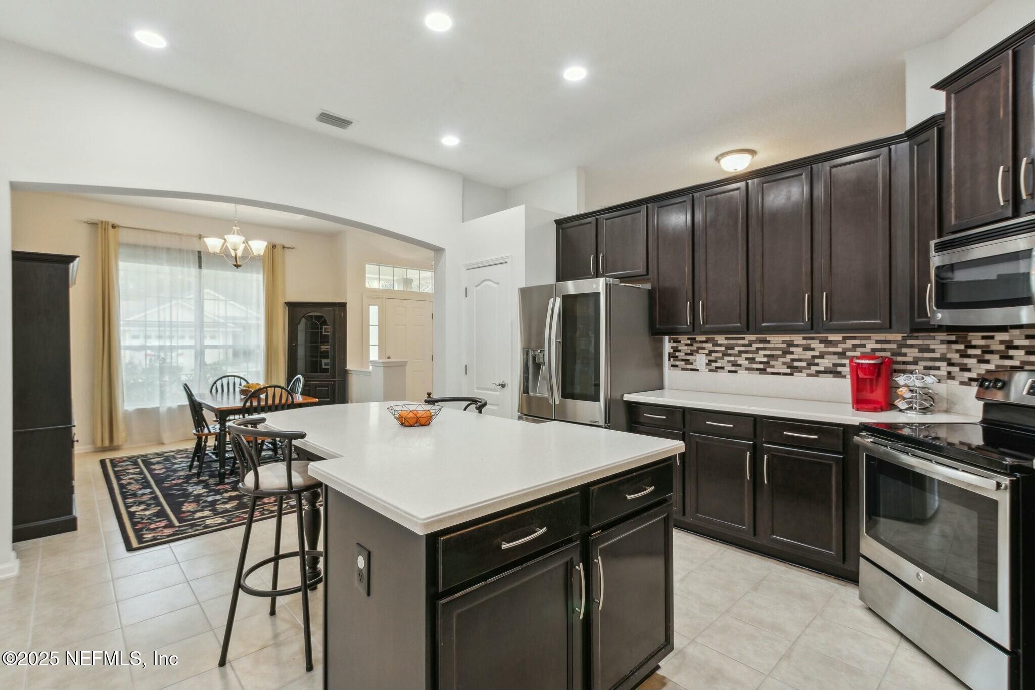 86197 Fortune Drive Yulee, FL 32097 - Photo 8 of 36 a kitchen with stainless steel appliances kitchen island granite countertop a stove refrigerator and cabinets