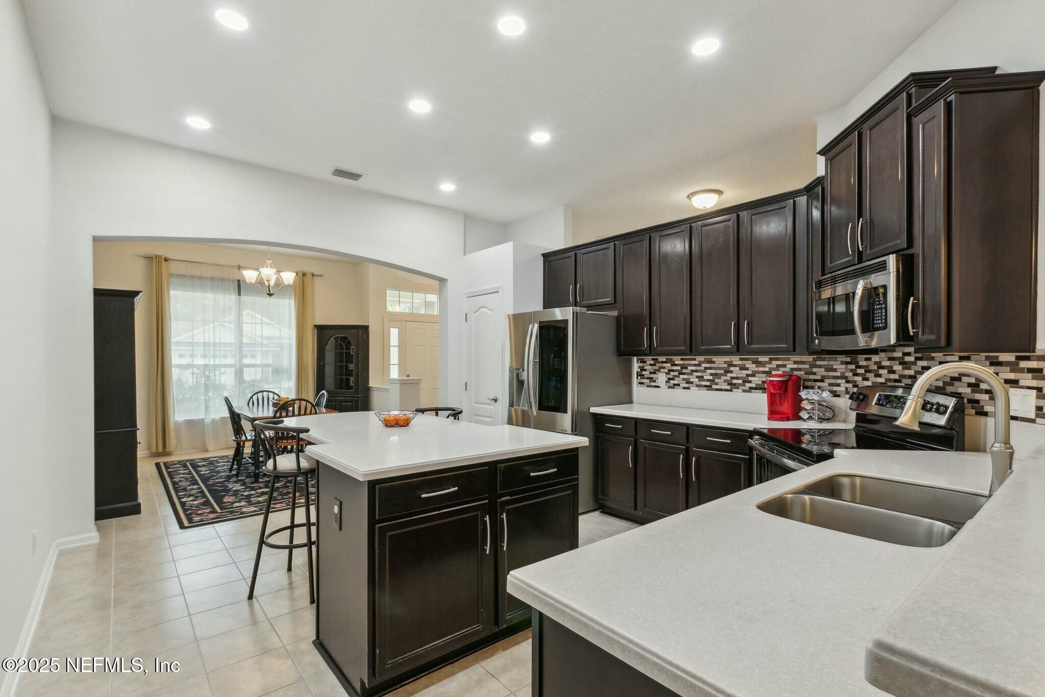 86197 Fortune Drive Yulee, FL 32097 - Photo 9 of 36 a kitchen that has a stove a table and chairs in it