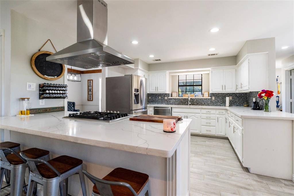 1246 Meadow Way Terrell, TX 75160 - Photo 30 of 39 a kitchen with a sink a stove and chairs with wooden floor