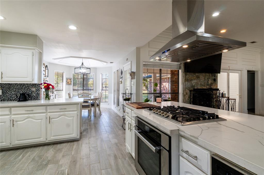 1246 Meadow Way Terrell, TX 75160 - Photo 8 of 39 a kitchen with a stove a sink dishwasher and white cabinets with wooden floor