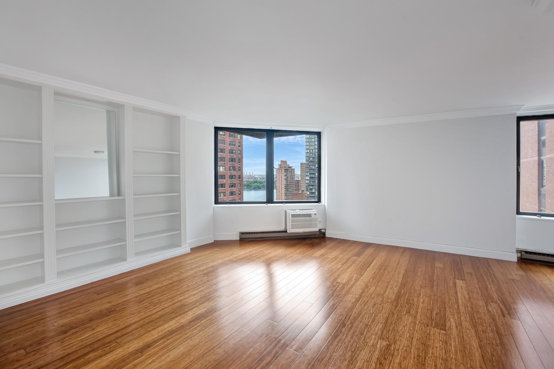 1623 3rd Avenue, Unit 21F Manhattan, NY 10128 - Photo 1 of 1 an empty room with wooden floor and windows