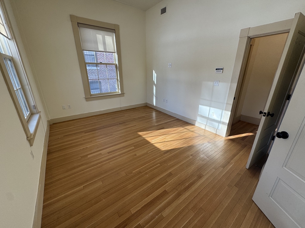 10 Linwood Street, Unit 3 Boston, MA 02119 - Photo 12 of 16 a view of an empty room with wooden floor and a window