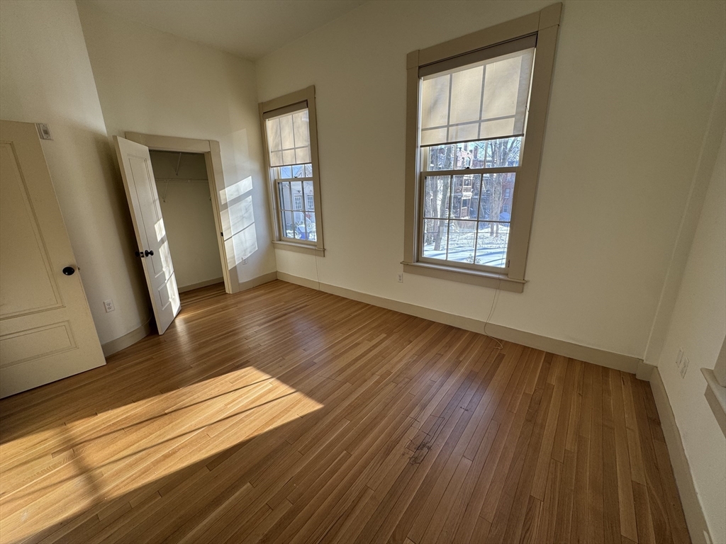 10 Linwood Street, Unit 3 Boston, MA 02119 - Photo 10 of 16 a view of an empty room with wooden floor and a window