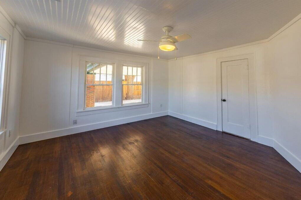 2215 18th Street, Unit FRONT Lubbock, TX 79401 - Photo 13 of 19 an empty room with wooden floor and windows