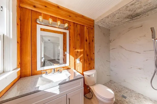 a bathroom with a sink a toilet and shower