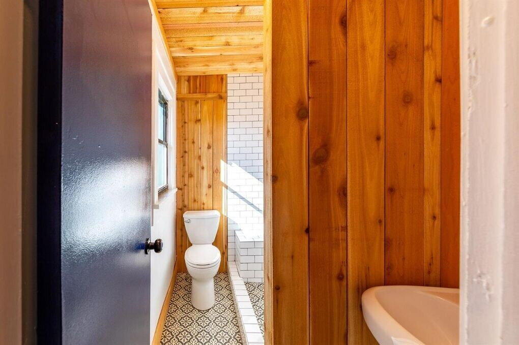 2215 18th Street, Unit FRONT Lubbock, TX 79401 - Photo 16 of 19 a bathroom with a granite countertop sink and a toilet