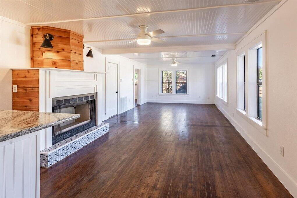 2215 18th Street, Unit FRONT Lubbock, TX 79401 - Photo 3 of 19 a view of an empty room with wooden floor fireplace and a window