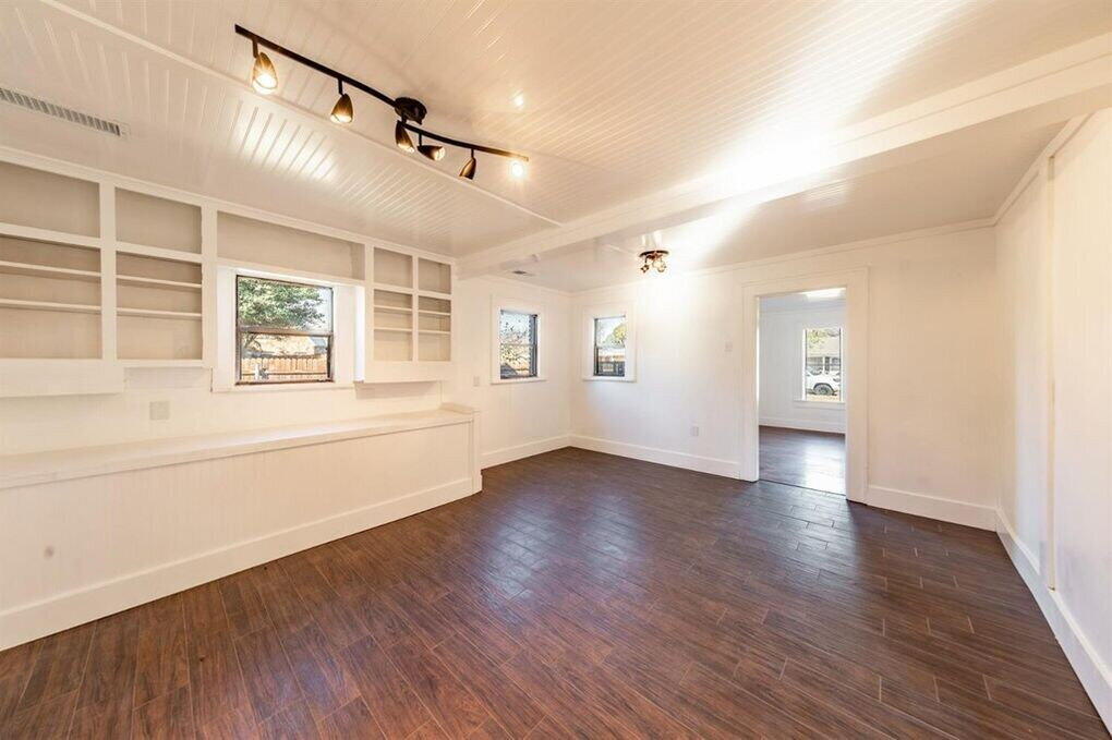 2215 18th Street, Unit FRONT Lubbock, TX 79401 - Photo 5 of 19 a view of an empty room with a window and wooden floor