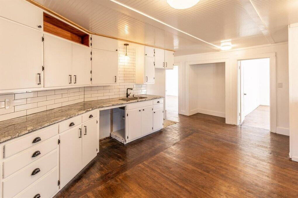 2215 18th Street, Unit FRONT Lubbock, TX 79401 - Photo 7 of 19 a large white kitchen with wooden floor