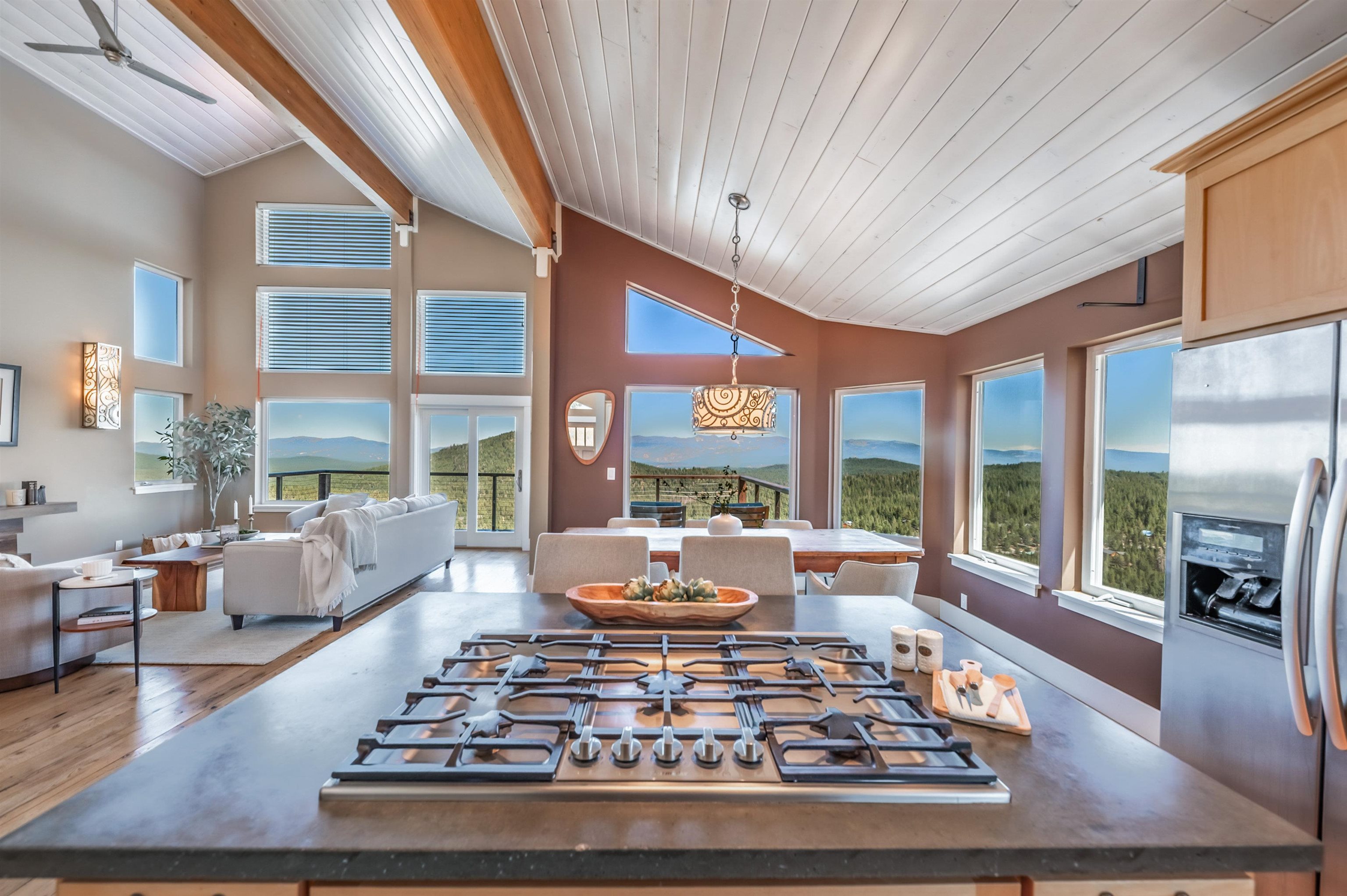 a living room with furniture large windows and wooden floor